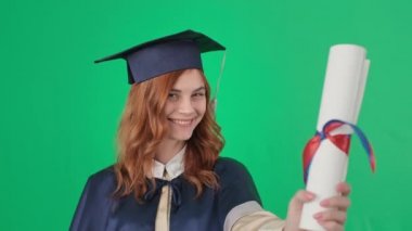 Akademik elbise, öpücükler ve diploma almış bir bayan mezun. Mezuniyet töreninde sevinçten havalara uçuyor.
