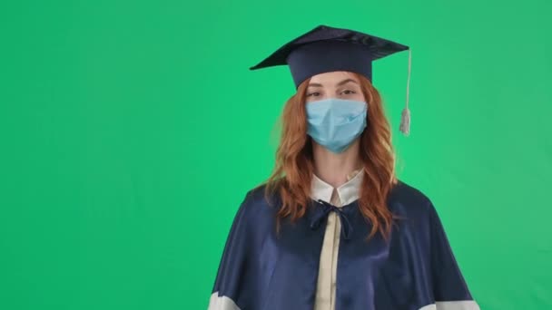 Utbildning på nätet, kvinnlig examen i en akademisk klänning och hatt visar diplom äckligt kastar den och lämnar grön skärm bakgrund, kroma nyckel — Stockvideo