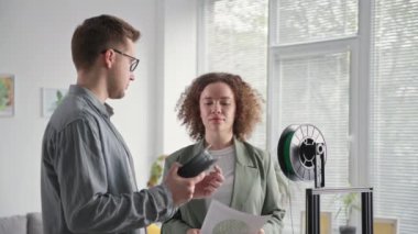 Genç ve yetenekli erkek ve kadın mühendisler modern teknolojiyi kullanıyorlar ve plastiği 3 boyutlu bir yazıcı ürünü için tartışıyorlar.