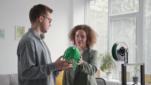 Getalenteerd man en vrouw paar in een lampenkap in hun handen gemaakt op een 3D-printer thuis — Stockvideo