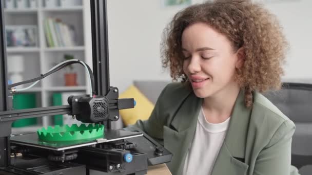 Moderne technologieën, charmante vrouw kijkt naar het werk van 3D-printer, glimlachen en kijken naar de camera — Stockvideo