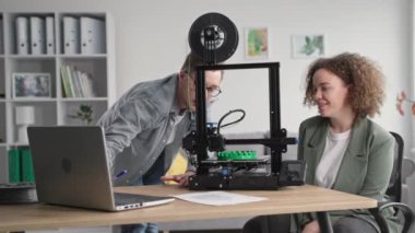 Yetenekli erkek mühendisler dizüstü bilgisayardaki modern teknolojileri kullanarak 3 boyutlu prototip baskısı yarattılar ve evde oturan 3D yazıcı