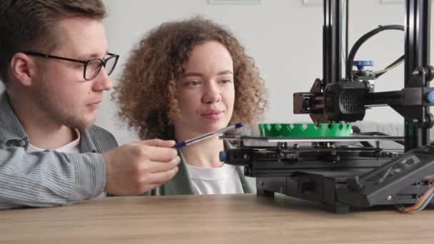 Modern technológiák, okos férfi és fiatal nő létre technológiai prototípus segítségével 3D nyomtatás otthon — Stock videók