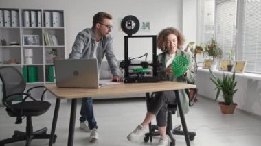 Modern ev geliştirme, yaratıcı erkek ve kadın modern teknolojileri kullanıyor ve evdeki 3D yazıcıda 3D modeller yaratıyor.