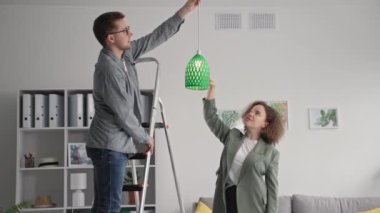 Modern tasarımcıların portreleri ev dekorasyonu ile ilgileniyor ve evdeki 3 boyutlu baskıya abajur asıyor, gülümsüyor ve kameraya bakıyor