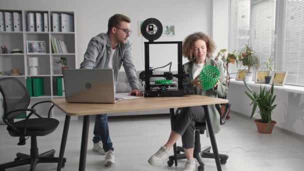 Современные улучшения дома, креативные мужчина и женщина используют современные технологии и создают прототипы 3D моделей на 3D принтере дома — стоковое видео