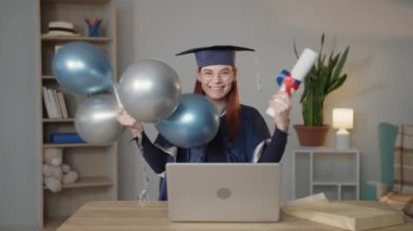 Modern öğrenme, mantodaki mutlu bayan öğrenci ve şapkası elinde balonlarla üniversite diplomasına seviniyor.