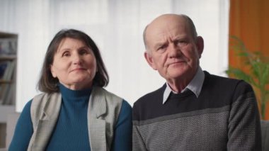 Yaşlı çift, çevrimiçi bir hasta randevusu sırasında bilgisayardaki video bağlantısıyla sağlık durumları hakkında doktorla konuşurken kameraya bakıyor.