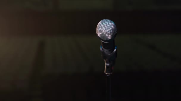 Microfoon voor ceremonie en conferentie staat op stand achtergrond van hal en lichtstralen uit de schijnwerpers — Stockvideo