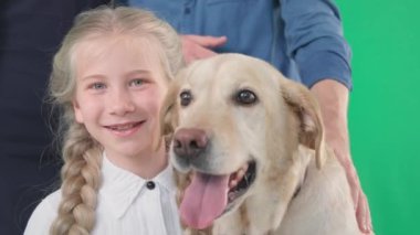 Labrador köpeği ve yeşil krom anahtar geçmişi olan neşeli gülümseyen kızın portresi. Yakın plan.
