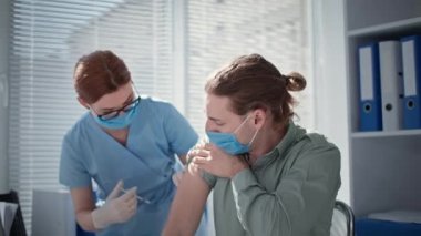 Kadın doktor aşı enjeksiyonları şırınga ve iğne ile tıbbî ofiste covid 'e karşı.