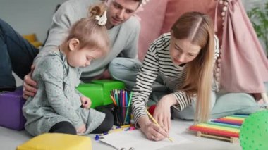 Çocuk gelişimi, ilgili ebeveynler kızlarıyla vakit geçirir ve aile tatili sırasında, aile arabasının arka planında kağıt üzerine kalem çizimleri yaparak eğlenirler.