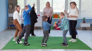 Down sendromlu çocuklarla dolu kapsamlı bir sınıfta gelişim faaliyetleri ve ders sırasında top daireler çiziyor.