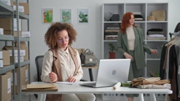 Retail, young female salesperson selling goods online and showing shopper a dress with a colleague in a clothing store, small business — Stock Video