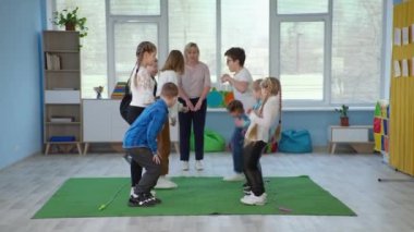 Engelli çocuklar terapi dersinde öğretmenleriyle eğleniyor.