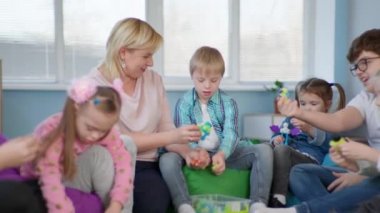 Kadın öğretmen Down sendromlu çocuklar için gelişim faaliyetleri yürütüyor ve geliştirme kiti topluyor.