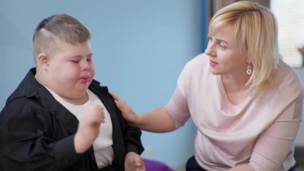 Związek z dzieckiem niepełnosprawnym, opiekuńcza nauczycielka pociesza płacz smutne męskie dzieci — Wideo stockowe