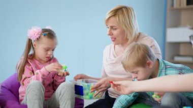 Kadın Down sendromlu çocuklar için ders veriyor.