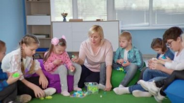 Kapsayıcı okulda öğretmenlik, ilgili kadın öğretmen sınıfta Down sendromlu çocuklar için eğitim seansları düzenliyor.