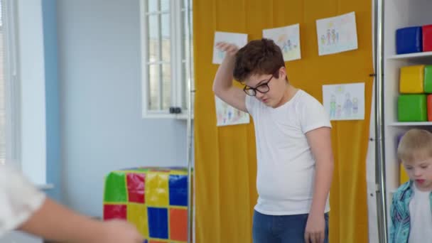 Niño con lana saltando cuerda durante clases educativas para niños con síndrome de Down en una escuela inclusiva — Vídeo de stock
