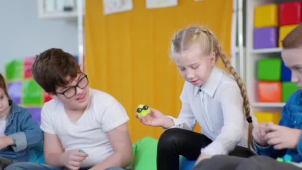 Chica sonriente se divierte en lecciones constructor con niño junto con el síndrome de Down durante las actividades de desarrollo en una clase inclusiva — Vídeo de stock