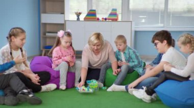 Bayan öğretmen, okulda ders sırasında Down sendromlu çocuklarla dolu kapsamlı bir sınıfta eğitici eğitim veriyor.