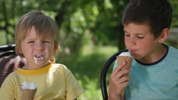 Cute boys enjoy eating a cool dessert with ice cream while relaxing on a hot summer day — Stock Video