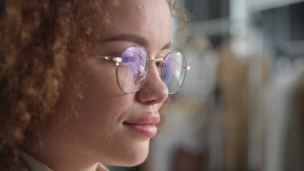 Retrato de uma jovem mulher com óculos para visão usa tecnologias modernas e olha para a tela de um tablet ou computador enquanto trabalha, close-up — Vídeo de Stock