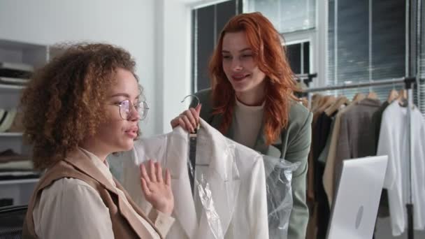 Magasin de détail, femmes propriétaires de petites entreprises prospères travaillent dans un magasin de vêtements et vendent des marchandises par Internet en communiquant avec un client via une communication vidéo sur ordinateur portable dans un magasin de vêtements — Video