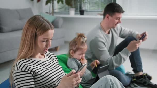 Problemas familiares, jovem casal com filhos pequenos do sexo feminino usa tecnologia moderna e mensagens de texto em redes sociais enquanto passa o tempo em casa — Vídeo de Stock