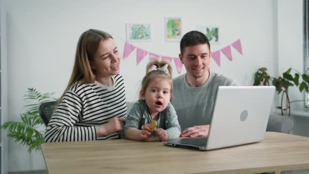 Comunicazione a distanza, genitori adorabili con un bambino di sesso femminile parlare tramite collegamento video con i nonni seduti a tavola a casa — Video Stock