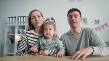 Çevrimiçi, mutlu genç bir kadın ve küçük bir kız çocuğu olan bir adam, yaşlı ebeveynlerini sosyal mesafelere bakarak dizüstü bilgisayarla tebrik ediyorlar.