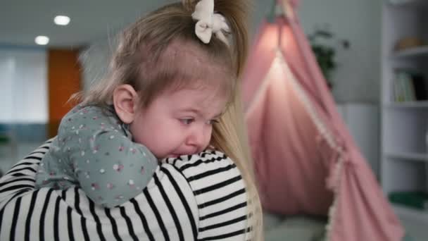 Материнство, любящая заботливая мама нежно утешает свою грустную маленькую дочь, родительская поддержка — стоковое видео