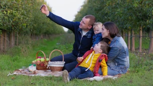 Сімейна фотографія, сімейна молода жінка з чоловіком і маленькими хлопчиками приймають селфі на смартфон — стокове відео