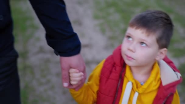 Parent-child relationship, little cute male child holds his beloved dad by hand — Stock Video