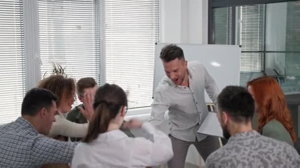 Succesvolle training, vrolijke mannelijke coach verzamelt steun van de handen van het werkteam tijdens een groepstherapie sessie — Stockvideo
