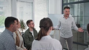 Grup terapisi, genç bir erkek işletme koçu grup terapisi yapar ve ellerini bir çember içinde toplar ve çalışma ekibiyle birlikte ayağa kalkar.