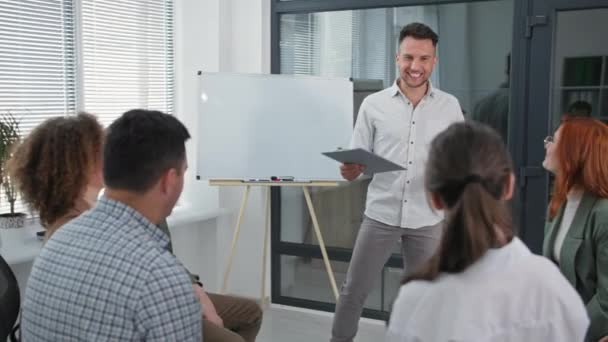 Formation en affaires, jeune orateur masculin rassemble les mains de l'équipe de travail en cercle lever et baisser puis applaudir au cours de la session psychologique — Video