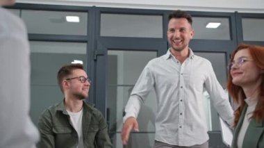 Psikoterapi seansı, bir grup iş adamı ellerini birleştirir ve ellerini kaldırır ve indirir ve sonra birbirlerini alkışlarlar çember halinde oturup ellerini birleştirirler.