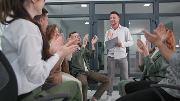 Erfolgreiches, glückliches Businessteam klatscht fröhlich in die Hände, während es im Kreis sitzt, während es im Büro professionell geschult wird — Stockvideo