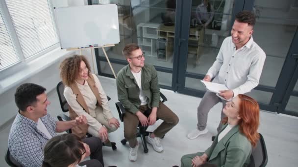 Formação motivacional, grupo de homens e mulheres jovens levantar e abaixar as mãos e depois aplaudir uns aos outros durante reunião motivacional profissional no escritório — Vídeo de Stock