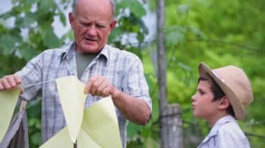 Şapkalı, şapkalı, çadır desenli bayraklarla süslenmiş mutlu yaşlı bir adam ve birbirine beş bahçe arkaplanı veriyor.