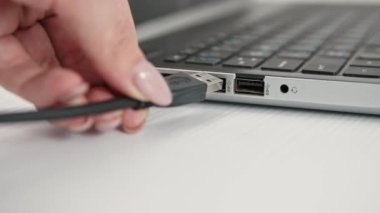 USB flash bellek anahtarını hafif arkaplanda dizüstü bilgisayarın portuna bağla, kapat