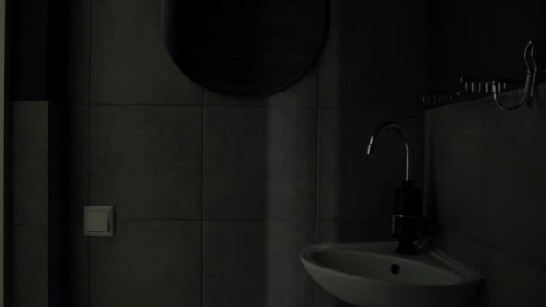 Tenaga listrik, wanita muda mematikan lampu dari kamar mandi setelah menggunakan — Stok Video