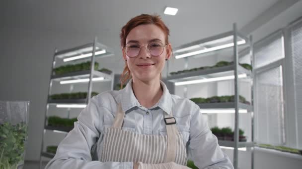 Online obchod, moderní žena farmář používá moderní technologie a prodává micro green v krabici on-line prostřednictvím videohovoru na notebooku sedí v pozadí polic — Stock video