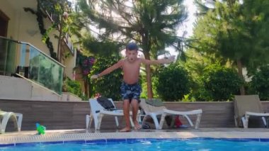 dive into pool, funny little boy jumps in blue water during active summer vacation, underwater shooting and air bubbles