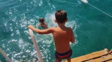 Yazın mutlu bir çocukluk geçir, küçük çocuklar iskeleden denize atlayıp annelerine atlarken eğlensinler.