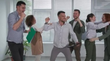 Başarılı bir iş, genç insanlar ofiste yaptıkları iş toplantısında seviniyorlar.