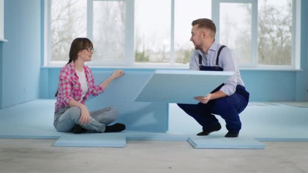 Married couple makes repairs in new apartment and puts insulation on floor to lay laminate — Stock Video