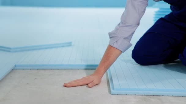 Samec stavitel zkontroluje teplotu podlahy při izolaci místnosti před pokládkou laminátu při fixaci, detailní záběr — Stock video
